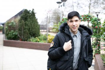 man standing in a courtyard wearing a coat