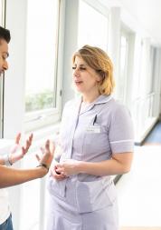 Two people speaking in a corridor